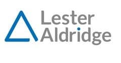 Lester Aldridge LLP logo featuring a blue triangle symbol and the firm’s name in grey text with a blue dot