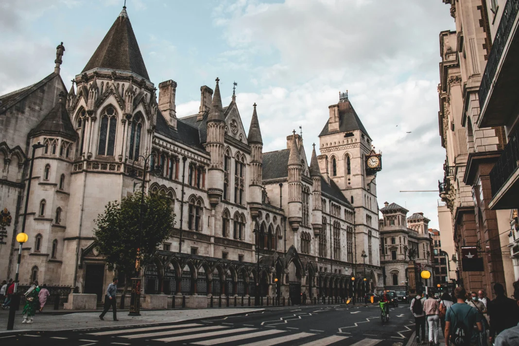 Royal Courts of Justice building in London, featuring Gothic architecture and a busy street